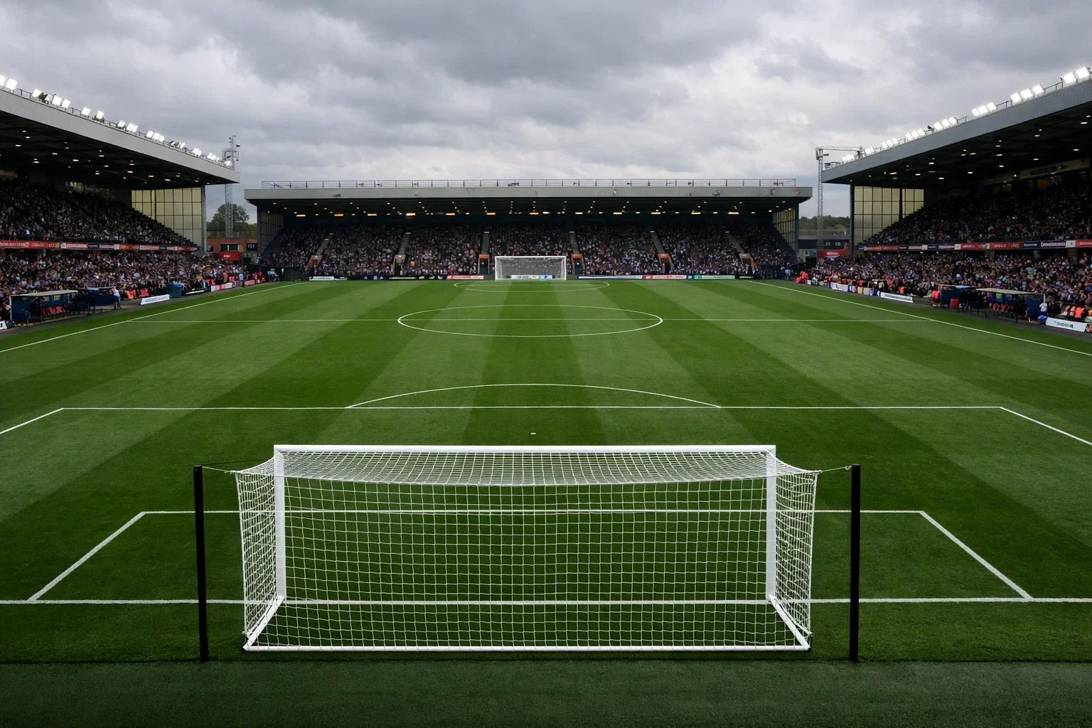 Partido de fútbol en estadio inglés con césped verde